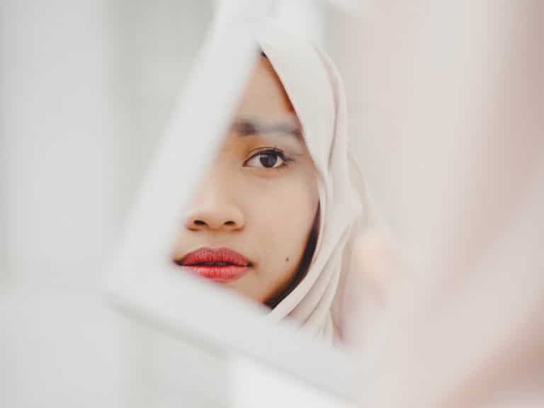 Image of muslim woman through a mirror