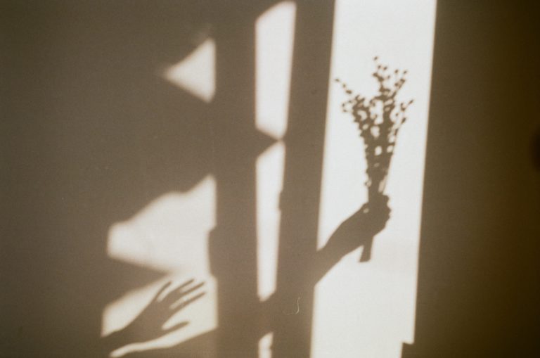 Shadow of someone holding a bouquet of flowers