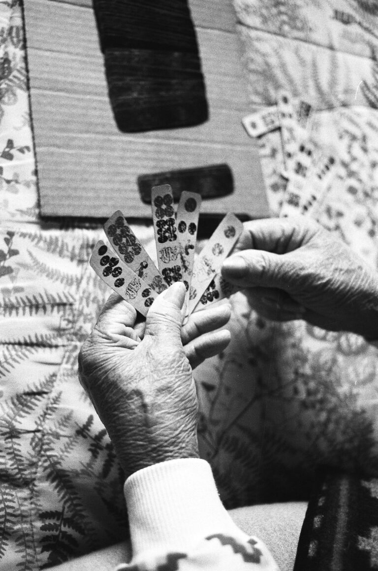 Elderly woman plays cards.